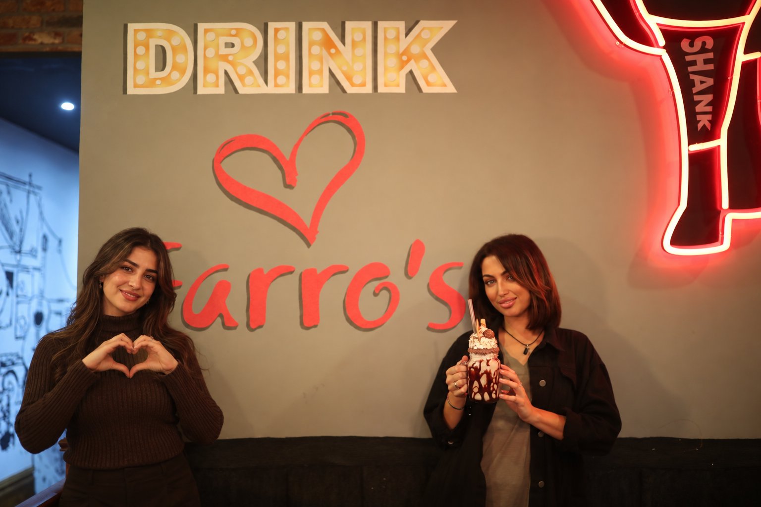 Friends celebrating a night out at Farro's Grillhouse with a loaded milkshake